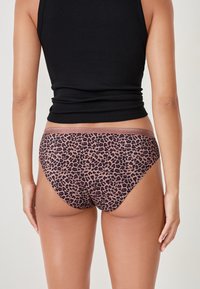 Różowe majtki w leopardzi wzór z gładką teksturą i kontrastową talią. Projekt cechuje niski stan i bezszwowe brzegi.