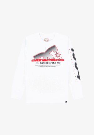 Biała koszula z długim rękawem zdobiona czarno-czerwonymi wzorami graficznymi, w tym napisem "DC Shoe Co USA" oraz logo na przodzie i rękawie.