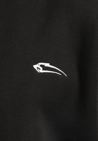 Tissu noir avec un petit logo blanc brodé, au design épuré et aérodynamique, présentant une texture lisse et un tissage serré.