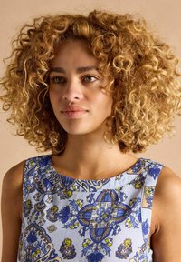 Hele sinine kleit siniste ja kollaste lillemustritega, ümarate kaelustega ja ilma varrukateta, valmistatud siledast kangast.