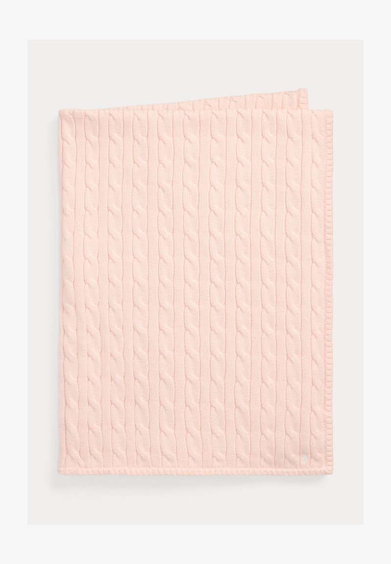 Puha, halvány rózsaszín kötött takaró függőleges kötésminta mintával, gondosan összehajtva fehér háttéren.