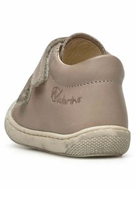 Chaussure en cuir beige avec un devant texturé et un arrière doux et arrondi. Équipée d'une sangle Velcro et d'une semelle flexible et à motifs. Logo de la marque en relief.