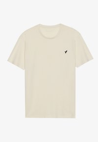 Short-sleeve t-shirt in cream with a crew neck and black bird logo on the left chest. Soft fabric with a smooth texture.