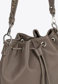 Hnědá kožená taška typu bucket s texturovaným povrchem, stříbrným kováním, zavíráním na šňůrku a kontrastním popruhem se zdobnými nýty.