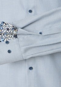 Blauw en wit gestreept overhemd met gestructureerde stof, knoopsluiting en bloemenmotieven op de manchetten.