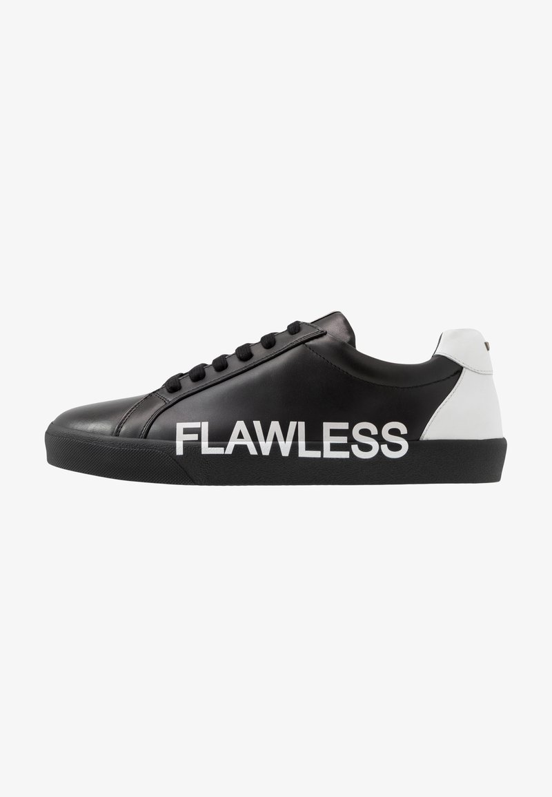 Sneaker nera basse con tallone bianco e grande testo bianco "FLAWLESS" di lato, caratterizzata da lacci neri e suola nera.