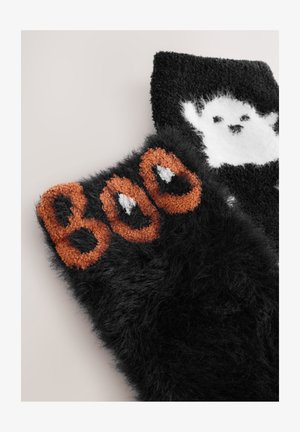 Černé chlupaté ponožky mají oranžový nápis "BOO" a bílý design ducha. Textura je měkká a plyšová, což zvyšuje pohodlí a teplo.