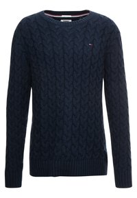 Marinblå kabelstickad tröja med långa ärmar, rund hals, ribbade mudd och nederkant, med en liten logotypdetalj på bröstet.