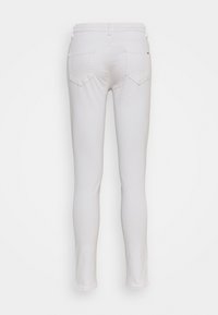 Jeans blancos con un corte ajustado, que cuentan con bolsillos traseros y una textura suave. El diseño incluye una cintura de altura media y detalles de hardware mínimos.