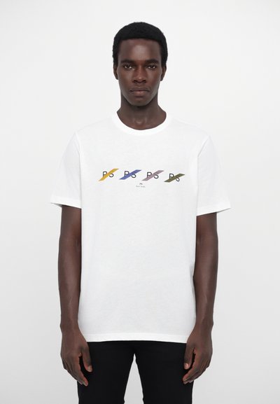 T-shirt en coton blanc avec des rayures diagonales multicolores et un design de texte sur le torse. Encolure ras du cou classique et manches courtes.