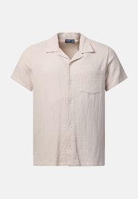 Chemise beige à manches courtes avec un tissu texturé et une poche poitrine unique, affichée sur un fond blanc.