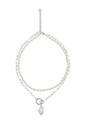 Dvojitý náhrdelník s malými bílými perlami na jednom řetízku a stříbrnými obdélníkovými články na druhém, s velkým nepravidelným perlovým přívěskem.