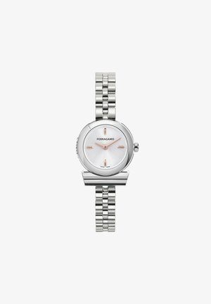Reloj de acero inoxidable plateado con una esfera redonda, dial texturizado en blanco, manecillas en oro rosado y una correa de eslabones. Cuenta con el logotipo de la marca.