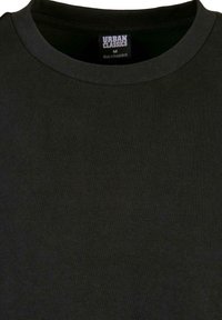 Black crew neck t-shirt made of cotton, featuring a textured fabric with a straight cut. Label reads "URBAN CLASSICS" and size 'M'.