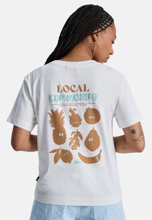 Weißes T-Shirt mit einem verspielten Grafikdruck auf der Rückseite, der braune Fruchtsilhouetten und den Schriftzug „LOCAL COMMUNITY“ in Braun und Blau zeigt.