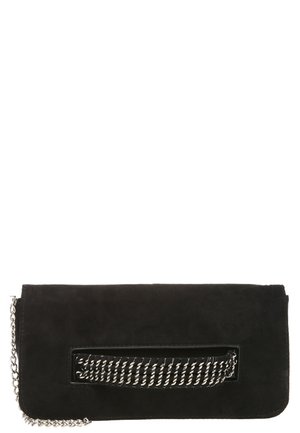 Pochette en daim noir avec poignée chaîne argentée et bandoulière chaîne argentée attachée sur fond blanc.