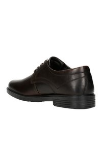Scarpa da cerimonia in pelle marrone con finitura liscia, punta arrotondata e tacco leggermente rialzato. Presenta cinque passanti per i lacci e una delicata cucitura laterale.