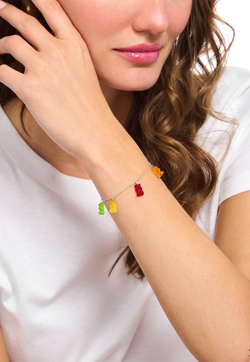 Pulsera de cadena de plata con encantos de ositos de goma en rojo, naranja, amarillo y verde. Los encantos son texturizados y coloridos, lo que añade un atractivo juguetón.