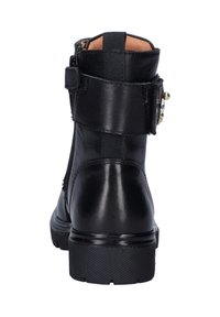 Zwarte leren enkellaars met een ritsluiting, textuur op de hak en een band met decoratieve hardware. Gladde afwerking met een ronde neus.