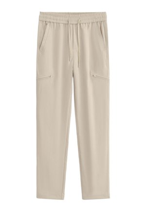 Pantalon beige décontracté avec taille élastique, cordon de serrage, poches latérales et poches zippées sur chaque cuisse.