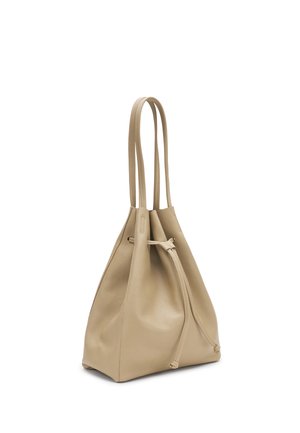 Beżowa skórzana torba typu worek z podwójnymi paskami na ramię i przednim zapięciem na sznurek, przedstawiona na białym tle.