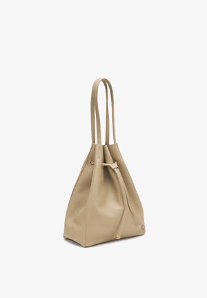Borsa a secchiello in pelle beige con doppi manici a tracolla e chiusura frontale con coulisse, mostrata su sfondo bianco.