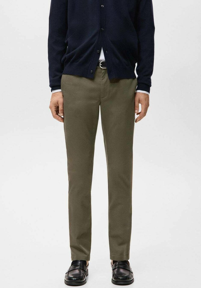 Chino verde oliva con taglio a gamba dritta in cotone, abbinati a un cardigan blu navy. Presentano una vita standard e una cintura.