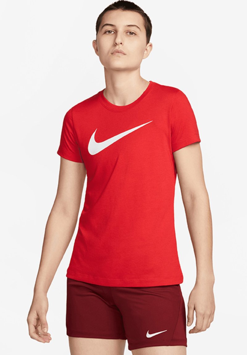 Červené bavlněné tričko s kulatým výstřihem a bílým logem Nike swoosh, v kombinaci s vínovými šortkami s bílým logem. Hladká textura.