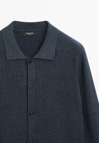 Dunkelblauer, gerippter Strickcardigan mit Kragen und schwarzen Knöpfen vorne, mit Etikett Massimo Dutti.