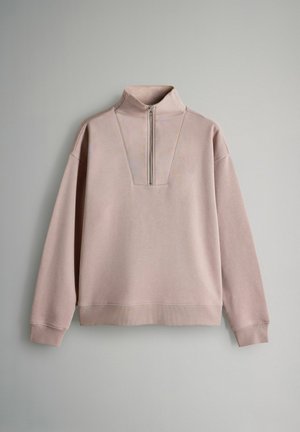 Ljusrosa sweatshirt i mjukt material, med halv dragkedja, hög krage och ribbade ärmslut. Loose-fit design med en minimalistisk look.