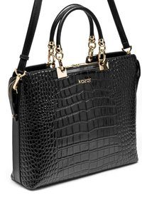 Musta krokotiilikuviollinen käsilaukku, jossa on kaksinkertaiset yläkahvat ja irrotettava olkahihna. Koristetty kullanvärisillä metalliosilla ja varustettu vetoketjulla.
