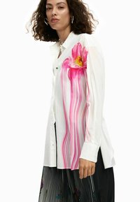 Valge nööbitav särk, millel on erkroosa lillemustriga vertikaalsed triibud. Pikalähedased varrukad ja lõdva lõikega, suured mansetid.