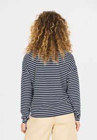 Marineblauwe en witte gestreepte langemouwen top met een relaxte pasvorm en ronde hals, gemaakt van zachte katoen, met een subtiele rugnaad detail.