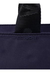 Navyblaue Stofftasche mit strukturierten schwarzen Griffen. Mit geprägt Logo "BF VUCH" nahe der oberen Naht. Glattes, strapazierfähiges Material.