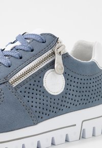 Baskets en daim bleu avec design perforé, semelle en caoutchouc blanche et fermeture éclair décorative. Comprend des lacets texturés et un patch logo en blanc.