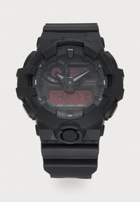 Montre numérique Casio G-Shock avec boîtier et bracelet en résine noire, affichage LED rouge, cadran rond et boutons proéminents pour la fonctionnalité.