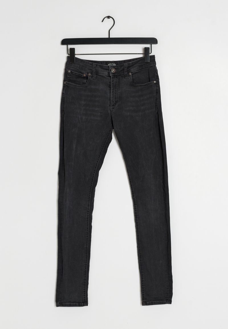 Czarne dżinsy z wąskim krojem. Posiadają pięć kieszeni, guzikowy zamek i szlufki na pasek. Tekstura pokazuje lekkie blaknięcie i zużycie.