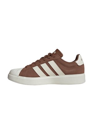 Zapatilla baja marrón con puntera blanca, suela blanca y tres rayas blancas en el lado.