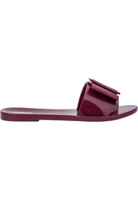 Infradito mauve in plastica lucida con un'ampia fascia decorata da un fiocco. Suola piatta con logo impresso.