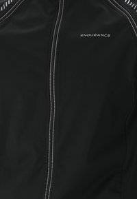 Veste de sport noire avec fermeture éclair à l'avant, bandes réfléchissantes sur les épaules et logo "ENDURANCE" sur le côté gauche de la poitrine.