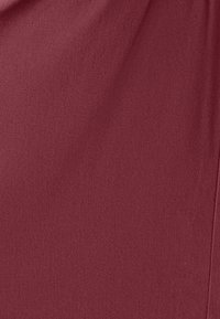 Bordová látka s hladkou textúrou a jemným vzorom tkania, s jemným závesom a čistým okrajom na jednej strane.