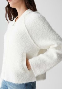 Witte fluffy zip-up jas van textuurstof, met ribbelmansjetten en zijzakken; heeft een ronde halslijn en een ontspannen pasvorm.