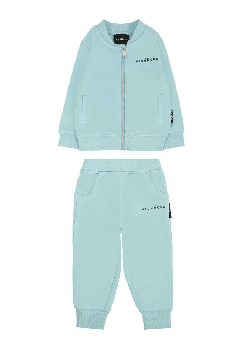 Jasnoniebieski dres wykonany z miękkiej tkaniny; kurtka zapinana na zamek z ściągaczami oraz dopasowane spodnie z kieszeniami i detalem z logo na obu elementach.