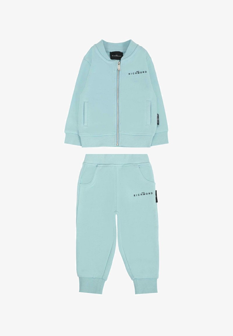 Jasnoniebieski dres wykonany z miękkiej tkaniny; kurtka zapinana na zamek z ściągaczami oraz dopasowane spodnie z kieszeniami i detalem z logo na obu elementach.