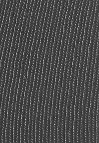 Tessuto nero con texture e un fine motivo a righe verticali. Il materiale sembra tessuto, con una leggera lucentezza che riflette la luce.