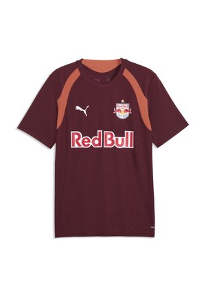 Rotbraunes Red Bull Salzburg Fußballtrikot mit orangenen Schulterakzenten, Puma-Logo und Red Bull Sponsor-Schriftzug auf der Vorderseite.