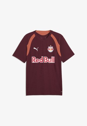 Bordowa koszulka piłkarska Red Bull Salzburg z pomarańczowymi akcentami na ramionach, logo Puma i napisem sponsora Red Bull z przodu.