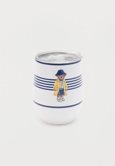 Λευκό μονωμένο ποτήρι με μπλε ρίγες και εικόνα μιας αρκούδας που φορά κίτρινο αδιάβροχο, μπλε καπέλο, ριγέ πουκάμισο και αθλητικά παπούτσια, με διάφανο καπάκι.