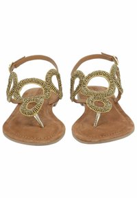 Sandali flat in suede marrone con dettagli decorativi in metallo dorato a forma di anello, fascia alla caviglia e separatore per le dita.