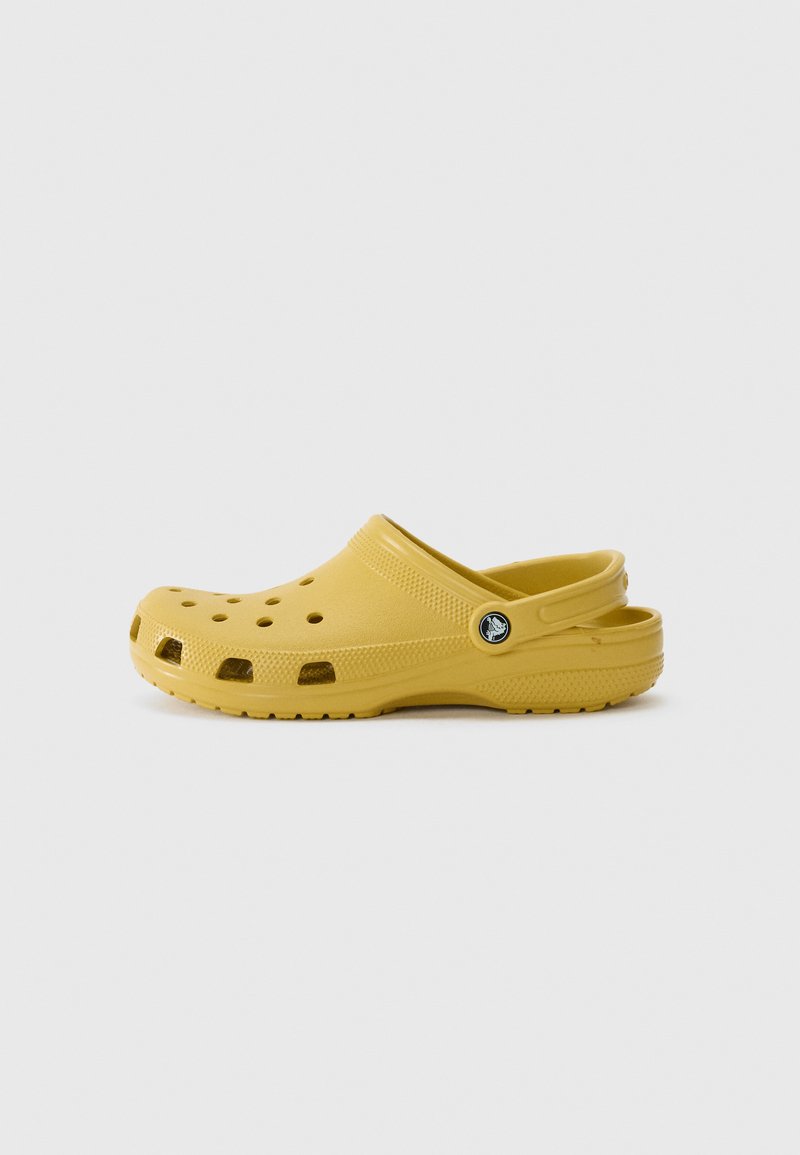 Yellow clogs made of lightweight material, featuring ventilation holes, curved back, and a round logo accent on the side. Smooth texture.